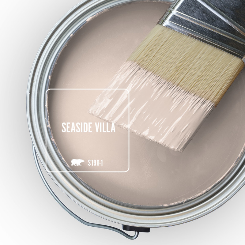 The top view of an open paint can, there is a haft dipped paint brush placed on top of the can, the color of the liquid paint is Seaside Villa. 