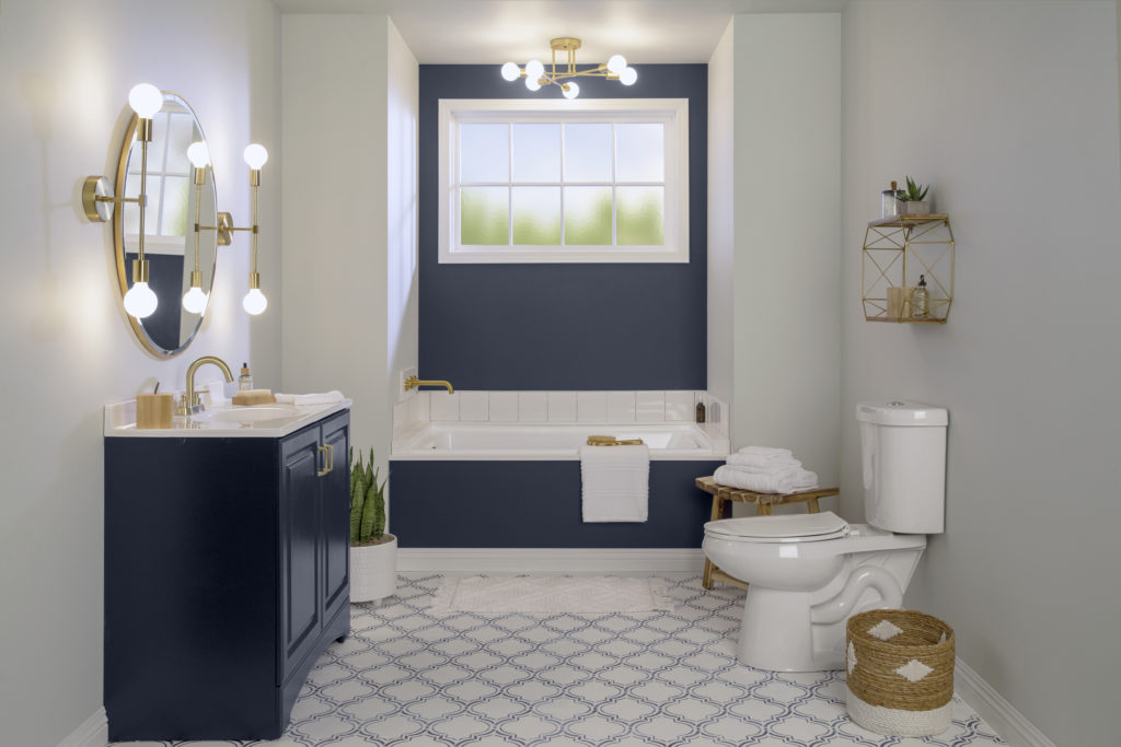 A completely DIY made-over bathroom. 
The walls have been painted in a trendy light warm gray and an accent color called Starless Night.   The hardware and lighting fixtures have been replaced with an elegant brass finish. The floor has a completely new look with a stylish stenciled design. 