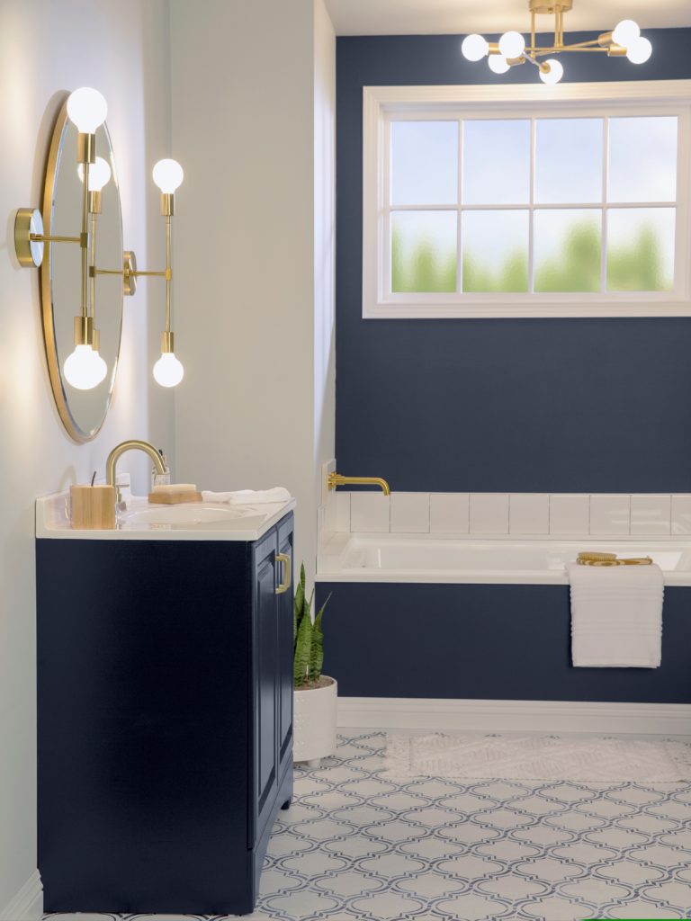 A beautiful bathroom that has been made over by painting the wall and vanity in a dark blue color. 