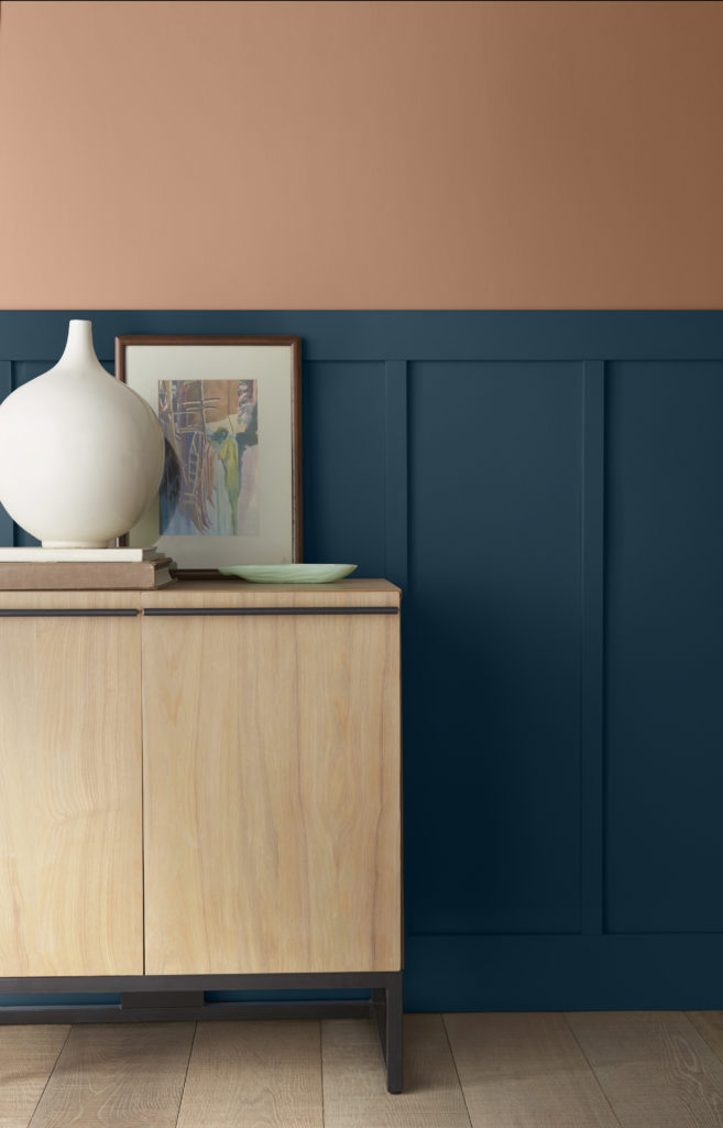 A feature wall painted in two different colors, the lower wall is a dark blue color called Nocturne Blue. The upper walls is painted in a terra cotta color called Canyon Dusk. 