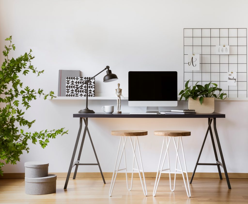 A desktop computer mock-up on an industrial desk in a scandinavian home office space with white walls. The color on the wall is called Nano White. 