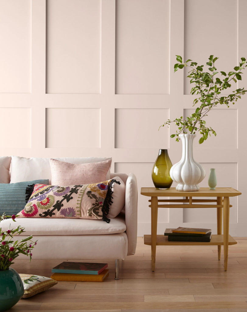 A living room with a decorative wall painted in a soft pink.