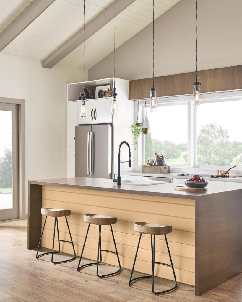 A kitchen with the island sides painted in a light burnt yellow color.