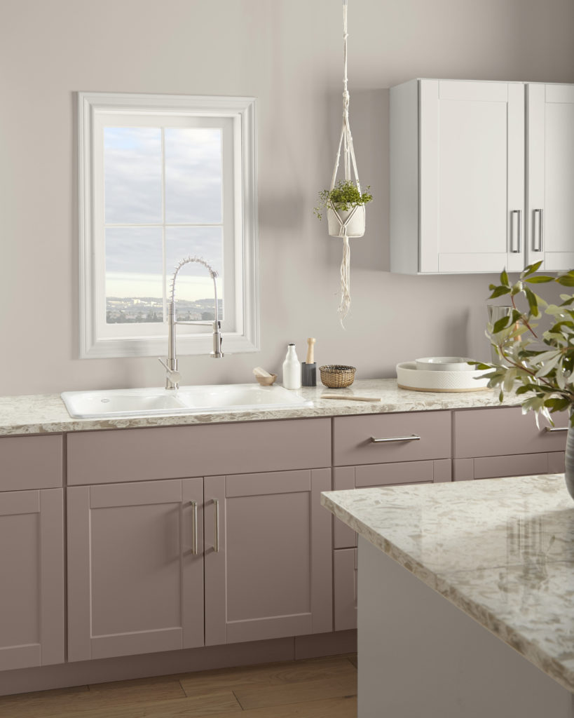 A kitchen with the cabinets painted in a mauve color.