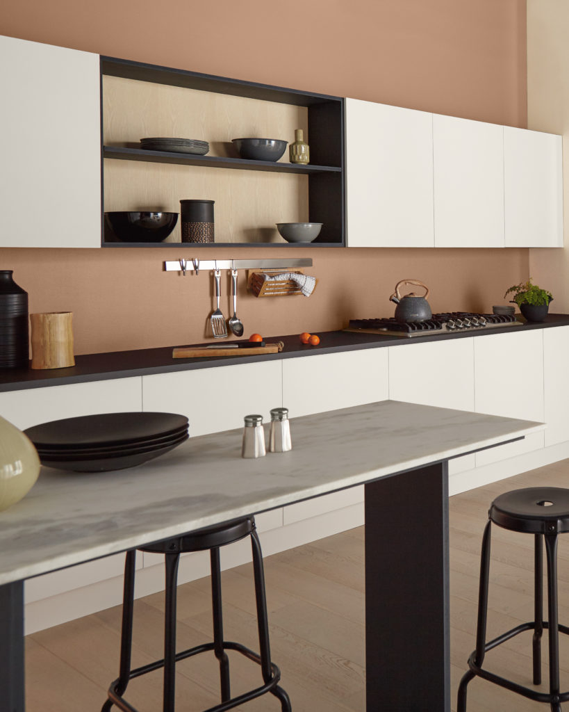 A kitchen with the walls painted is a light burnt orange color.