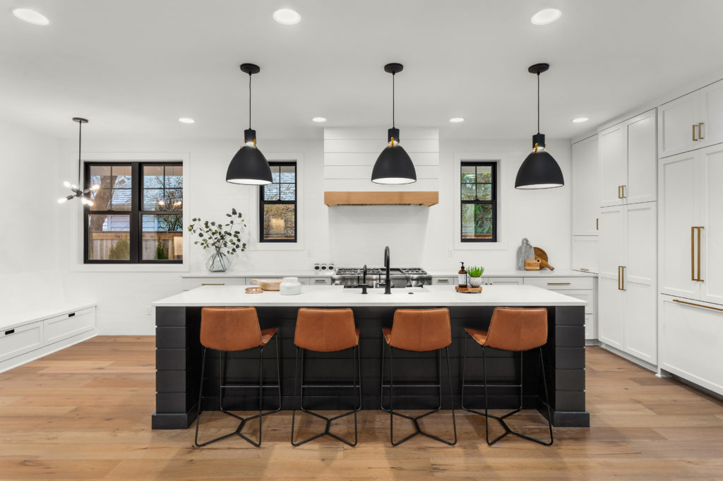 Kitchen in newly constructed luxury home, the walls and kitchen cabinets are painted in white color called Whisper White, the kitchen island is painted in black. 