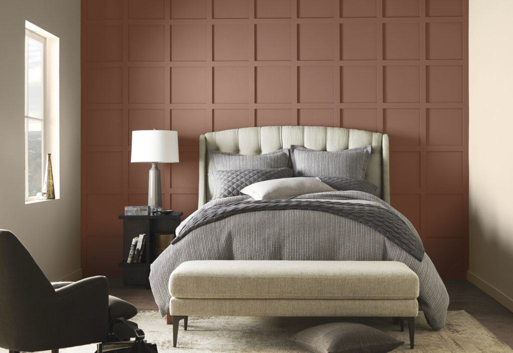 Bedroom image with square paneled accent wall in a deep brown orange bronzed hue. Remaining walls in a creamy tone.