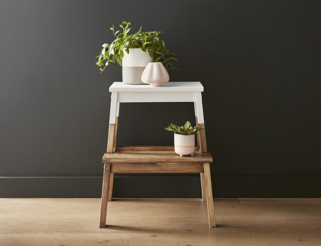 Step stool that has been stained and painted then decorated with plants.