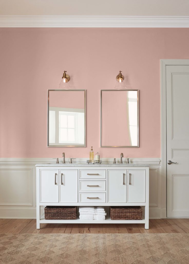 A classic bathroom with a his and hers vanity sink, the color on the walls is light pink color.