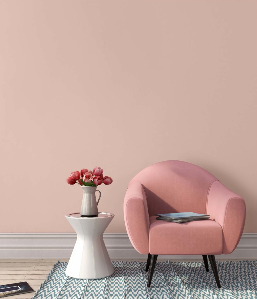 Interior in pink color with a chair, a table and stylish copper floor lamp, the color on the walls is called Sunwashed Brick.  