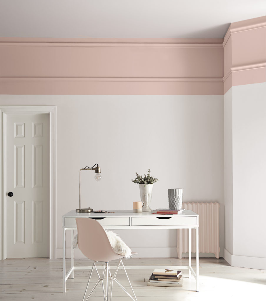 A mid-century modern bathroom with white walls and pink chunky trim. 