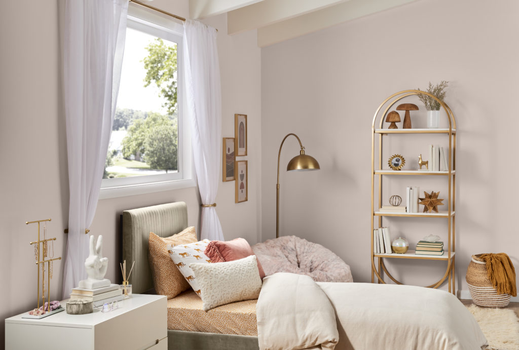 Chic room image with walls in a warm saturated pink hue. Gold furniture accent pieces.