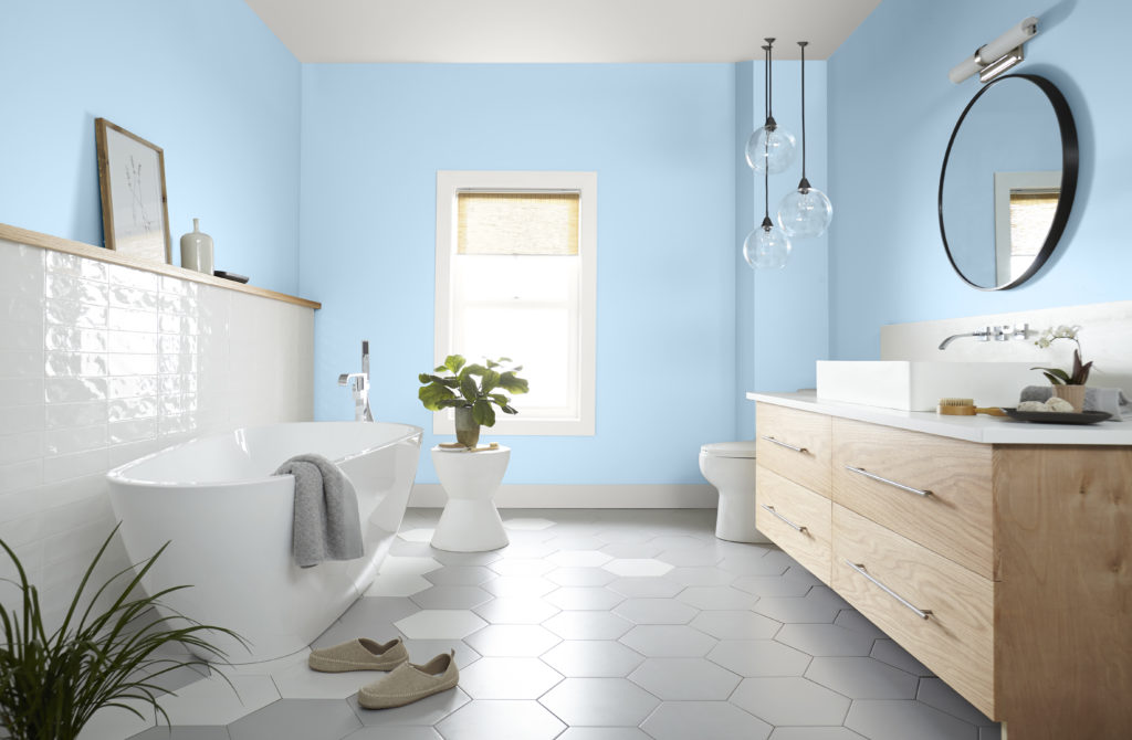 Bathroom painted in a blooming blue spring color in After Rain. 
Free standing tub, modern tiles and wood toned cabinet. 