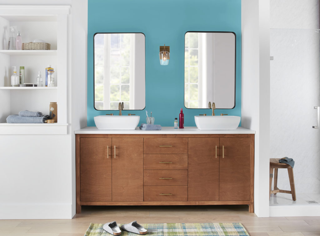 A bathroom with two sinks. The accent color featured behind the vanity and mirrors is a youthful blue color called Explorer Blue. 