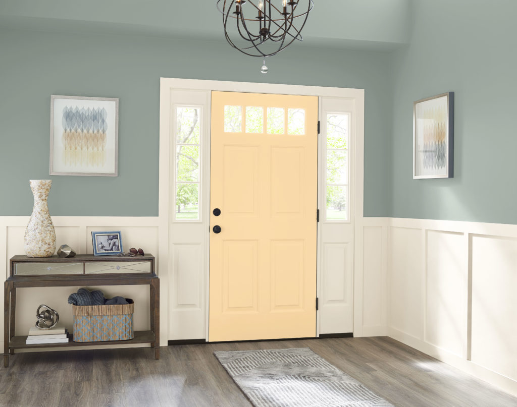 A soft green entryway featuring a yellow door painted with a cheerful yellow called Corn Stalk , this glowing color creates a striking focal point.