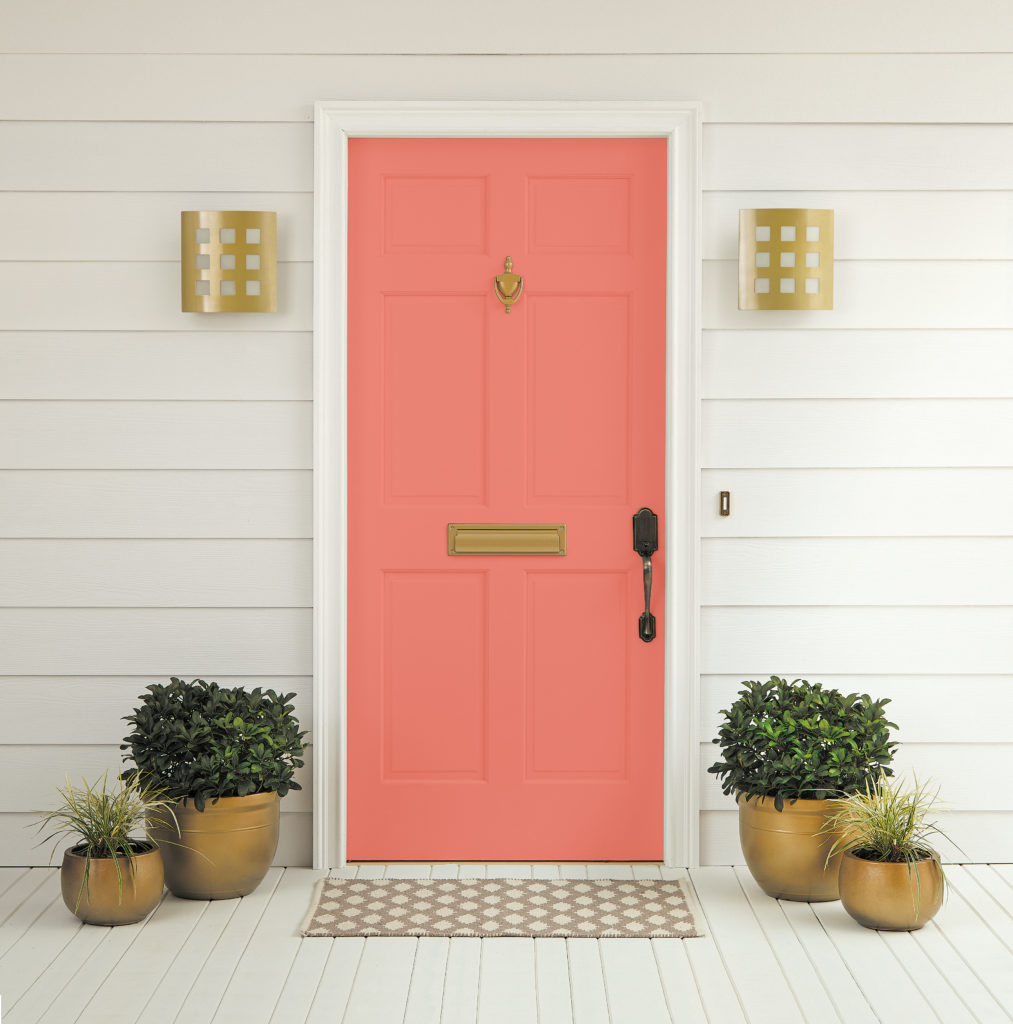 Accent front door in Watermelon Slice P180-5 surrounded with pots of plans and gold accents. 