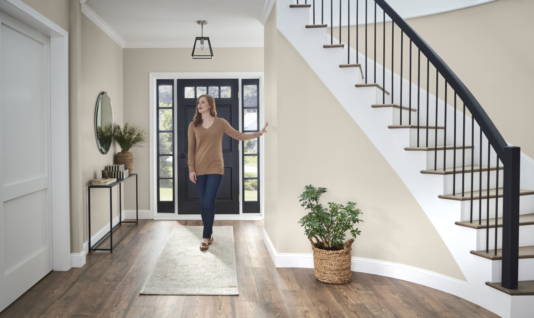 An entryway with a person walking through. The walls are painted in a warm gray hue.