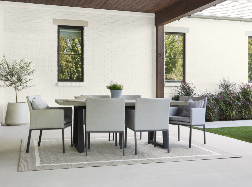 A covered patio and  white brick wall make a great background for an outdoor dining area.  Blank Canvas is a light neutral color that provides any living or dining design with a sleek and clean look. 