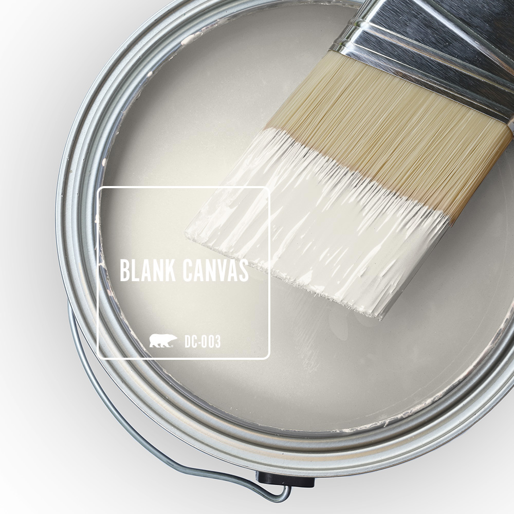 The top view of an open paint can with wet paint and a half-dipped paint brush, the color featured is Blank Canvas.