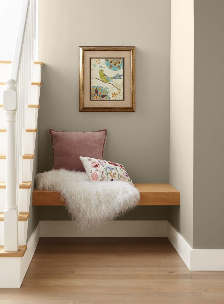 A cozy nook by the home staircase. A nice little corner to sit, relax of even read a book.  The walls are painted with a warm neutral color, Even Better Beige. 