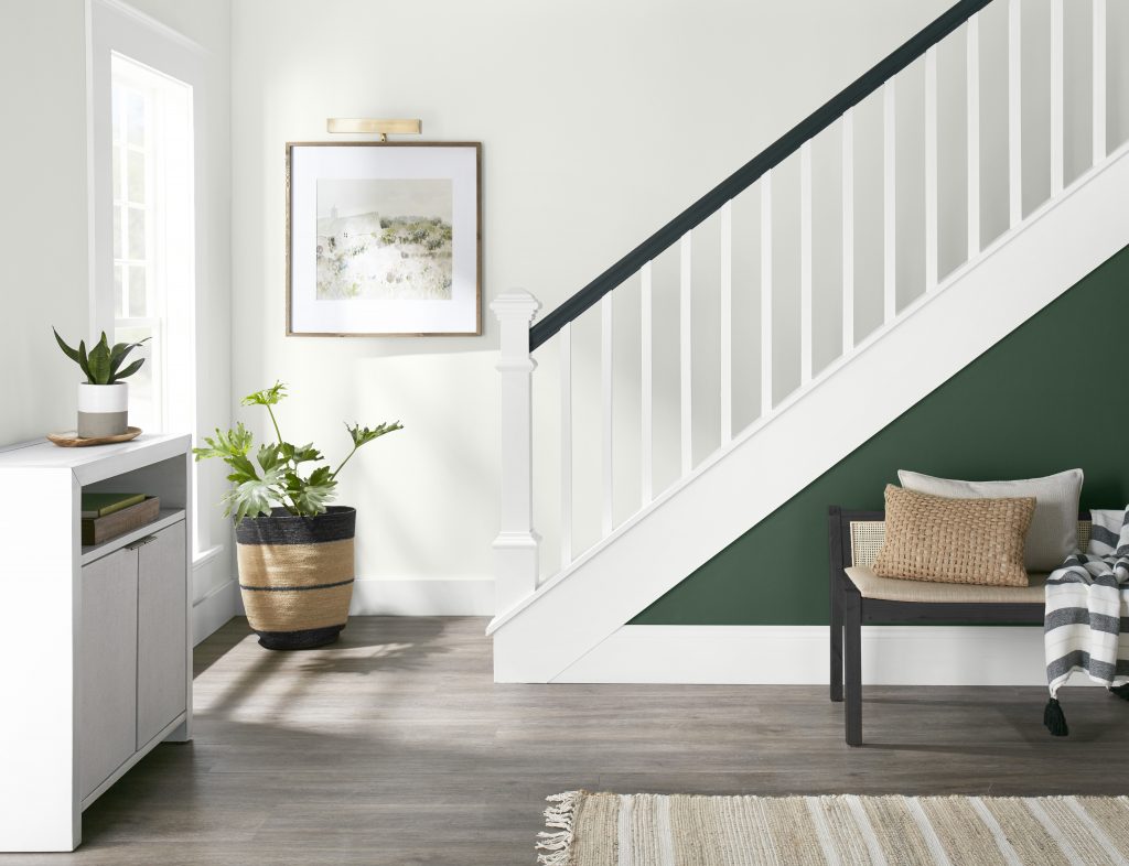 Casual entryway and staircase with a green accent wall. 