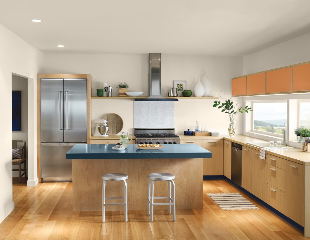A Scandinavian  white kitchen with  retro inspired accent colors  such as rusty orange, and dark navy blue.  