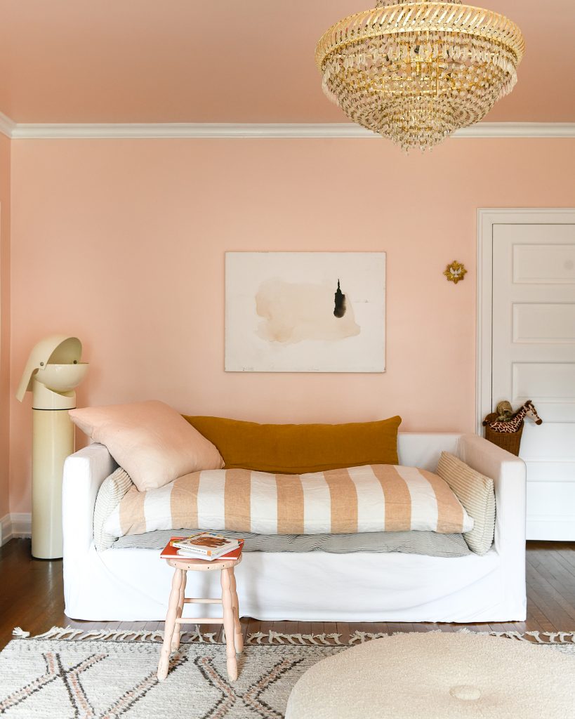 A daybed against a pink painted wall.