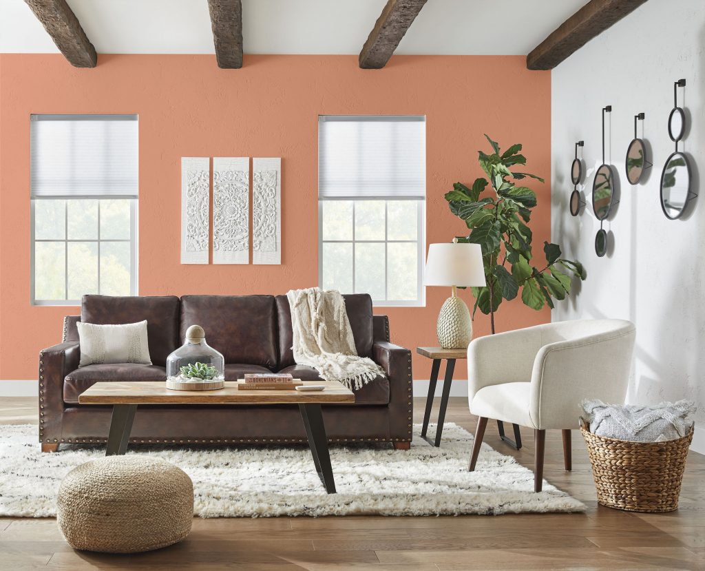 A living room with a bright peach orange hue painted on the wall.