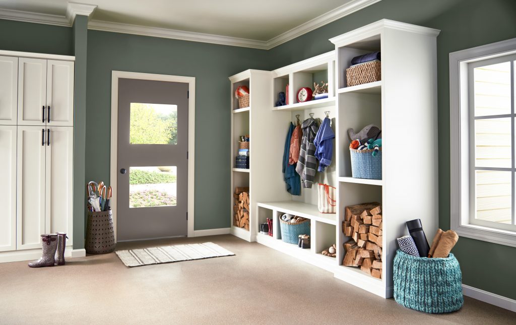 A home entry-mudroom with storage and built-in bench. the walls are painted with a green color called Pinecone Hill. 