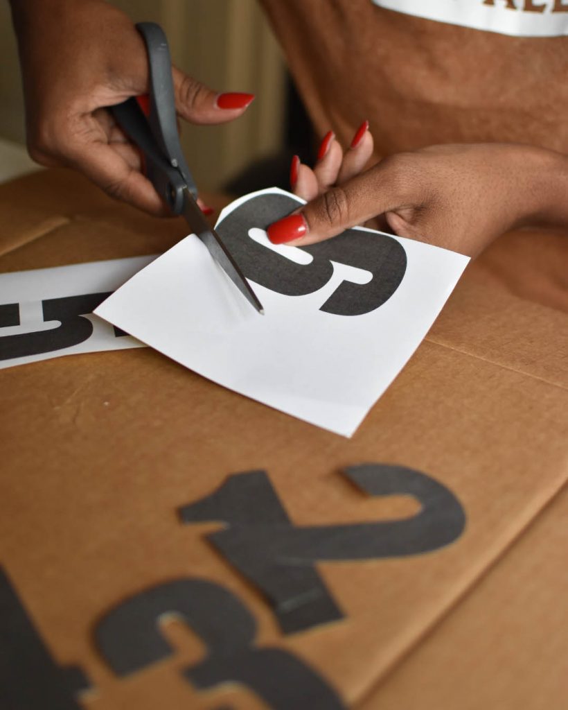 A person cutting out letters from paper.