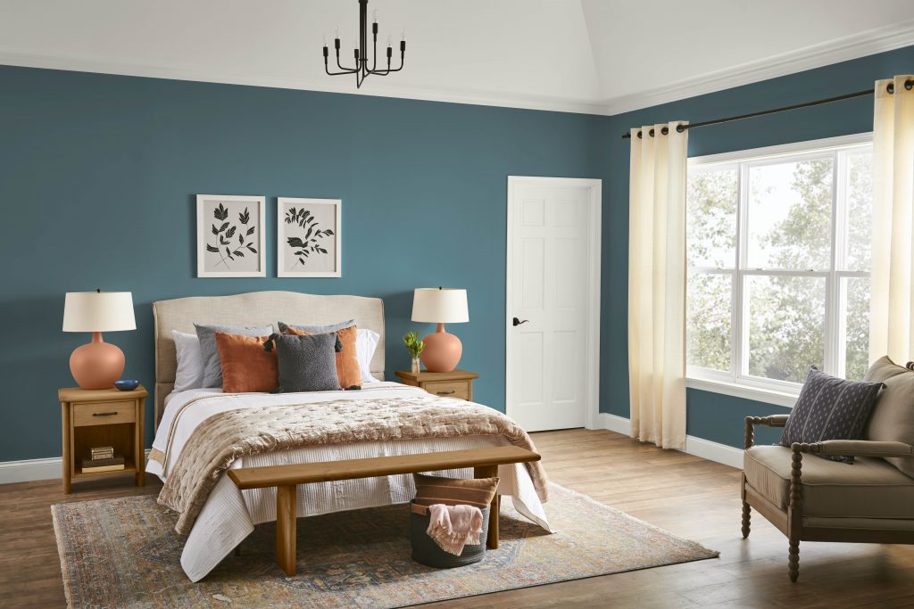 A casual bedroom featuring teal color walls and terracotta decorative accents. 