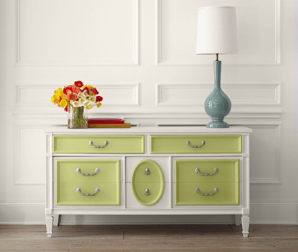 A hallway with a dresser. The dresser is painted white with bright green color accents around the drawers.