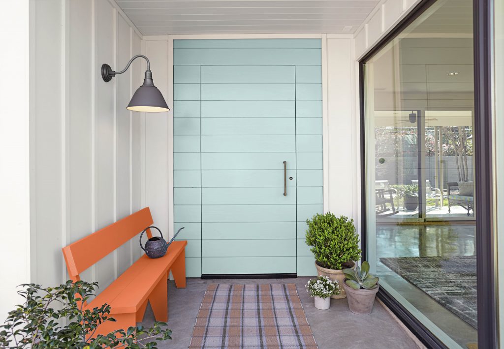 Exterior door image with decorative planters and a bench.