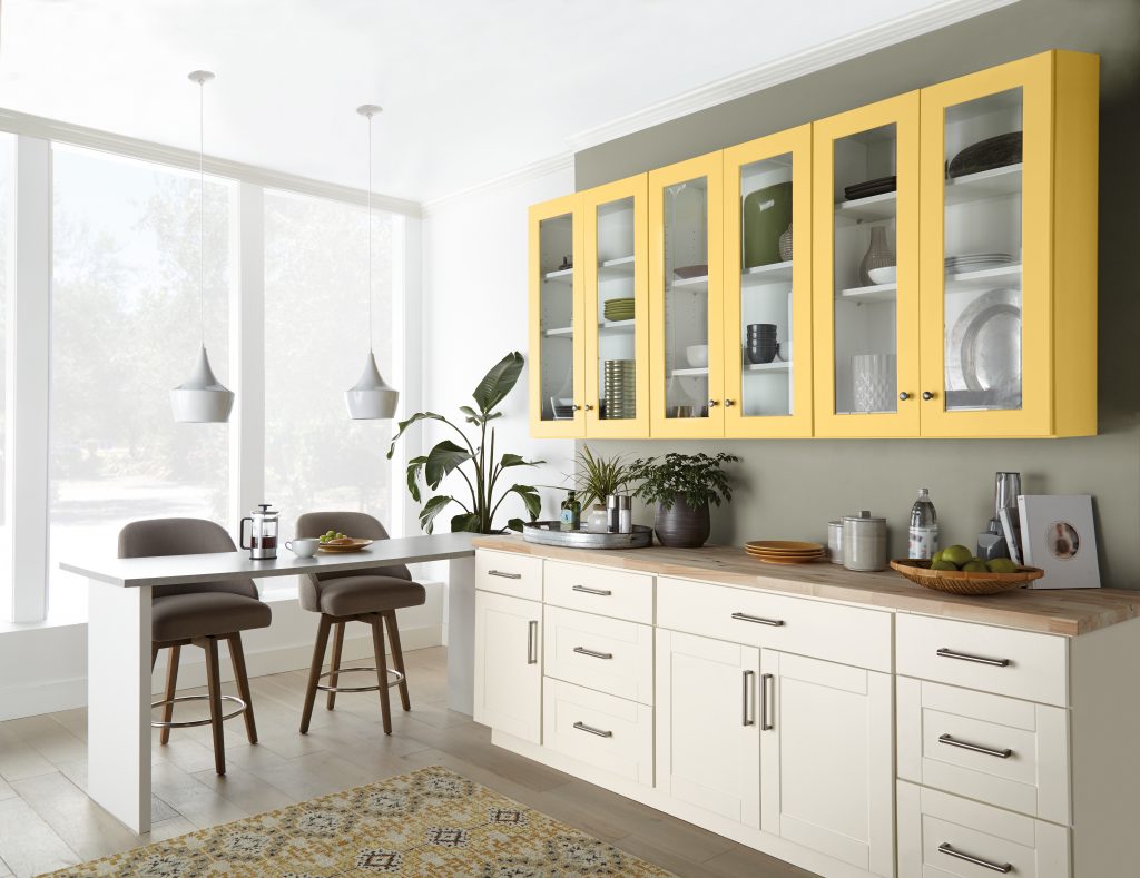 A dining/kitchen area with bright yellow upper cabinets.