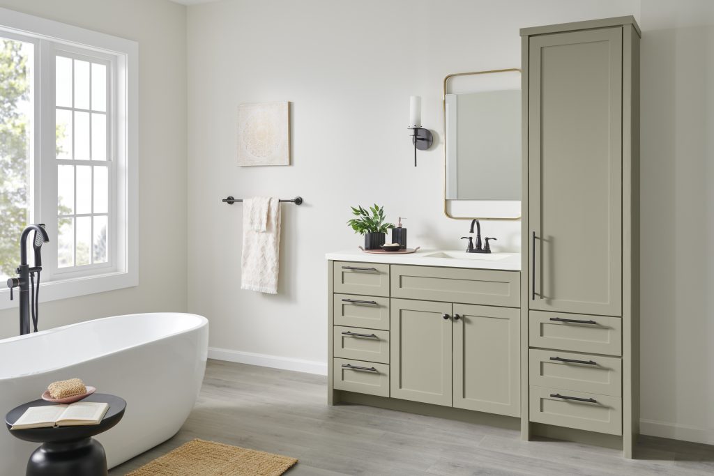 Bathroom with a muted green color for the cabinets and a crisp white for the walls.