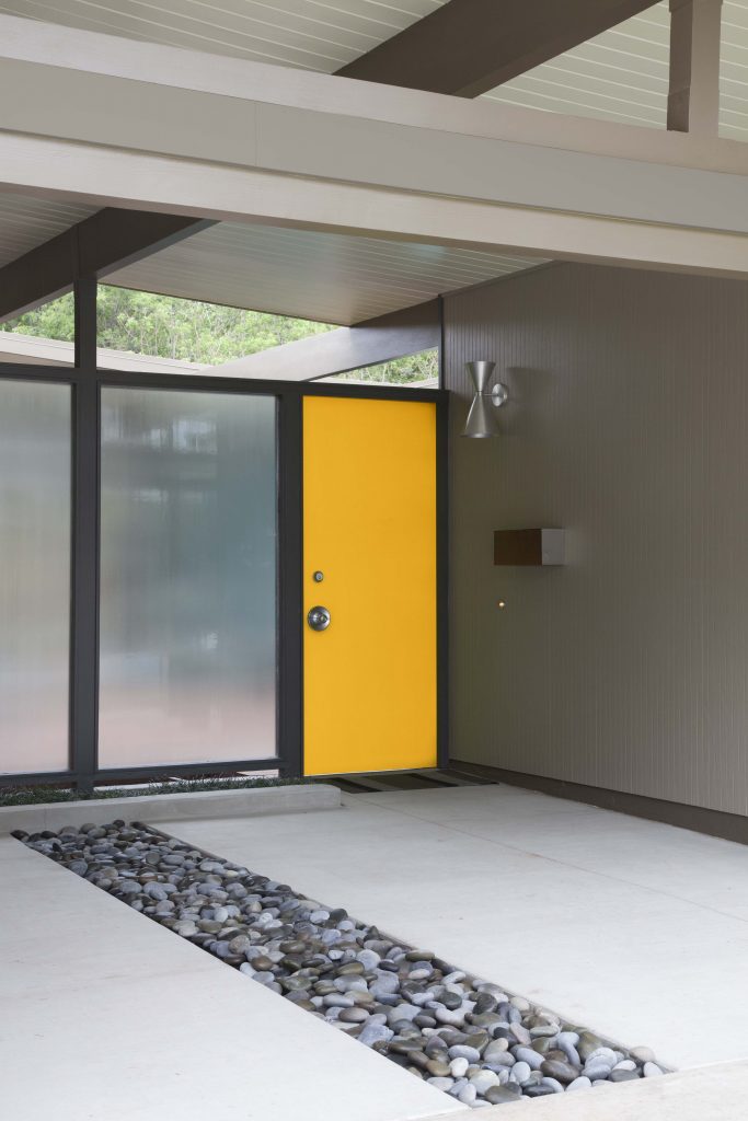 A home showing the front door painted in a yellow hue.