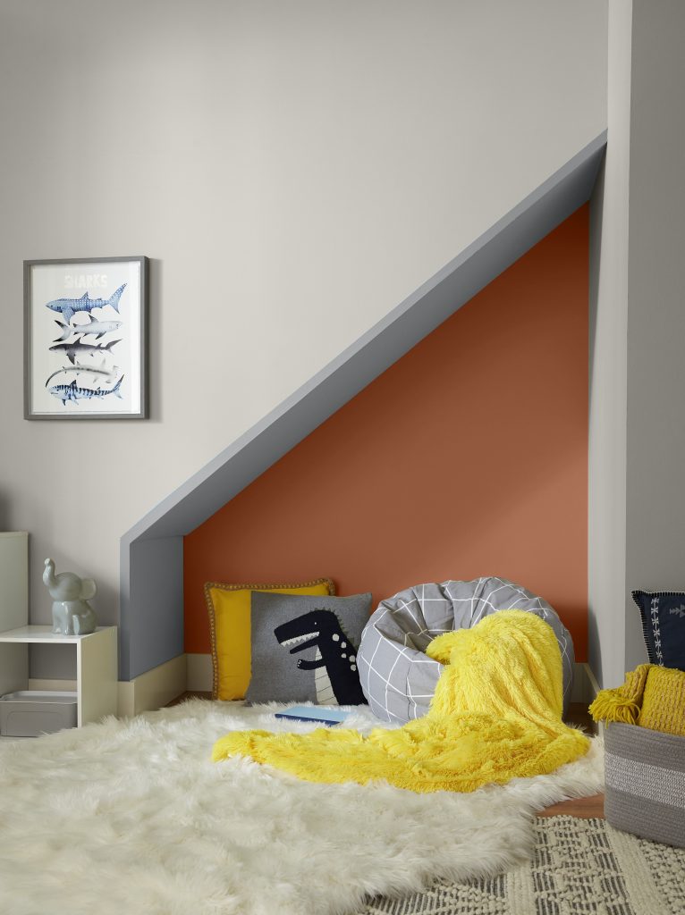 A kids room with a play area nook.  The space is decorated with gray and yellow colors.  The accent wall on the nook is Orange Flambe. 