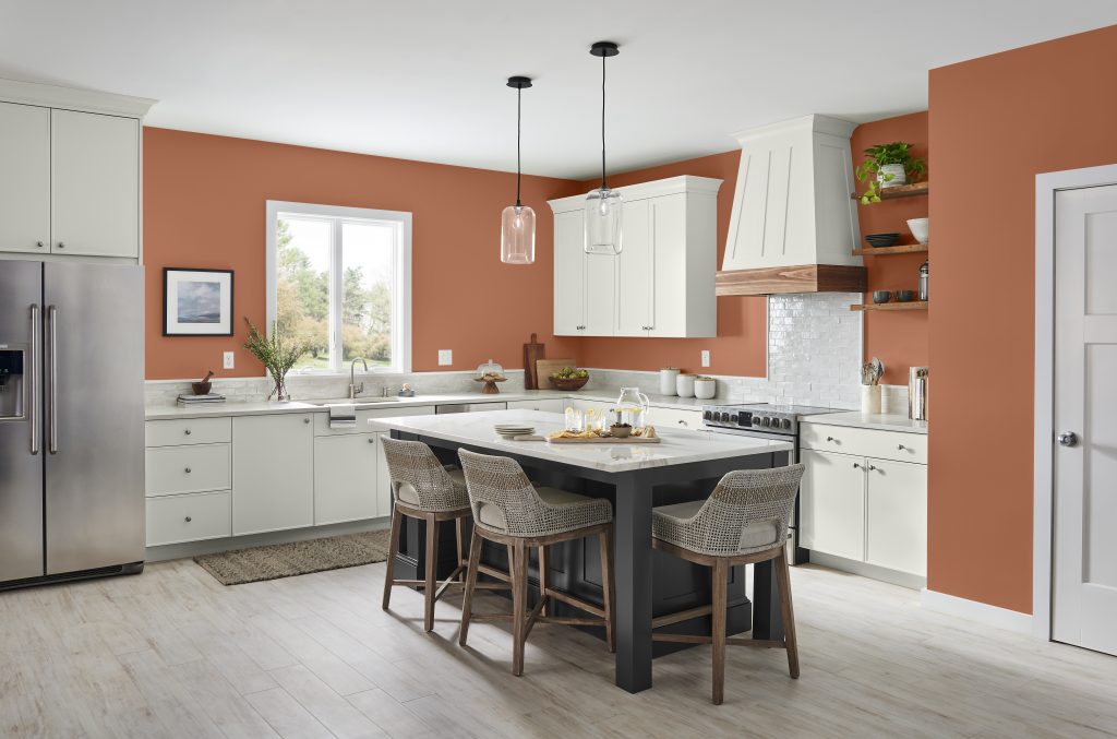 A large kitchen with white cabinets and a dark smoky gray color called Cracked Pepper.  The color of the wall is Orange Flambe. 