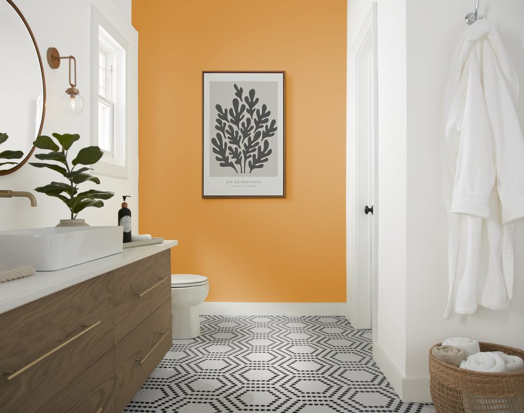 A bathroom painted in white with an accent wall painted in a vibrant yellow hue.