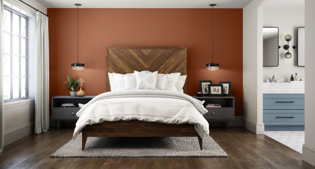 An Unban-Industrial style master bedroom and bathroom.  The walls are painted in a toned off-white color called Smoky White, the accent wall in the bedroom is painted with Orange Flambe. Bathroom cabinet was a blue color called Adirondack Blue. 