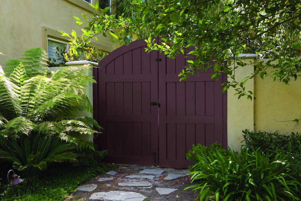 A gated entry with the door painted in a deep purple hue.