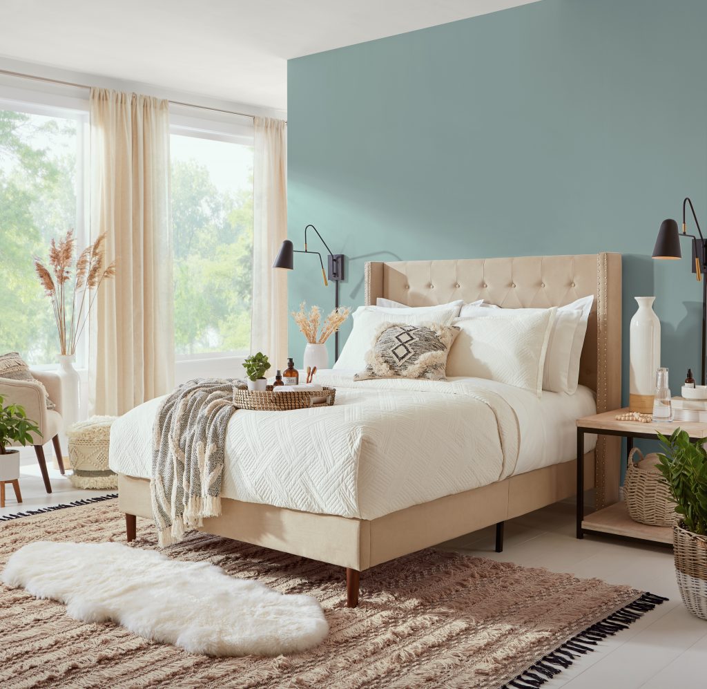 A bedroom with the headboard wall painted in a medium toned blue hue.