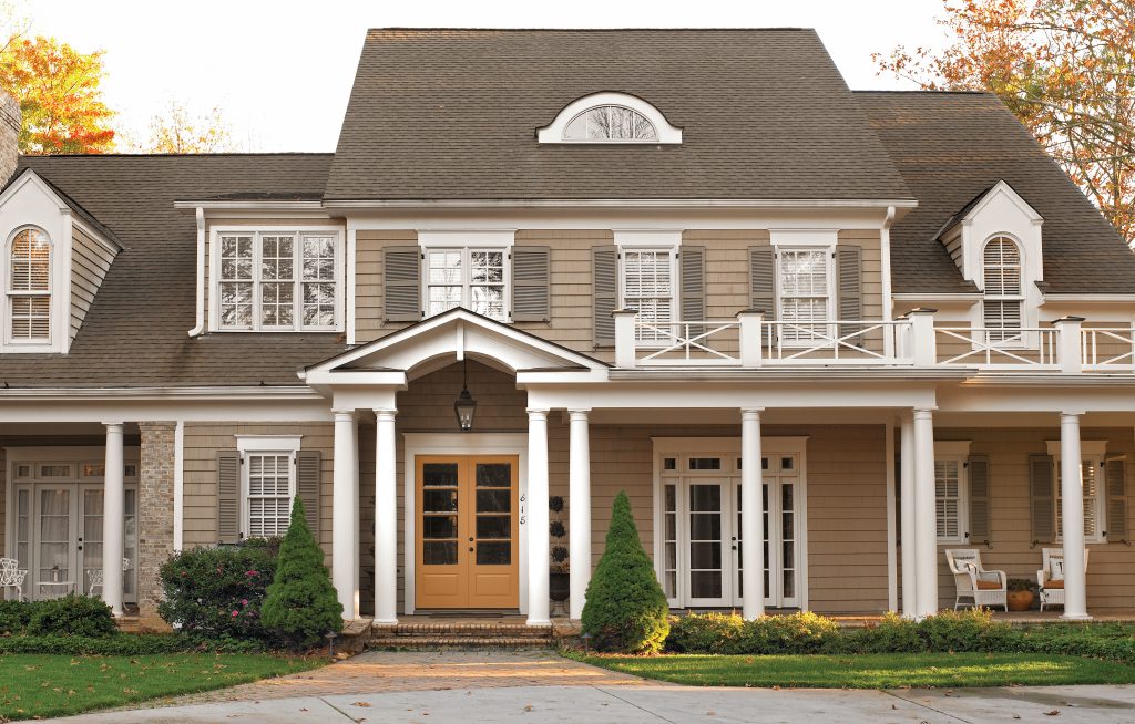 A home painted in a brown color with the door in a golden orangy-yellow hue.