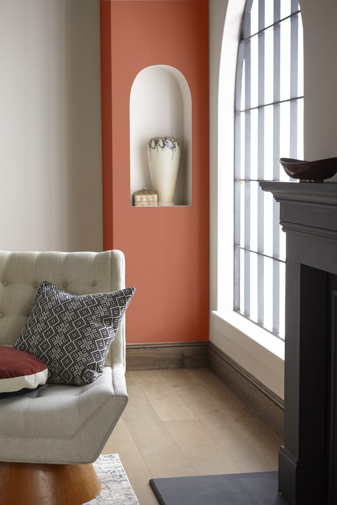 A living room with an accented area painted in a bold orange hue.