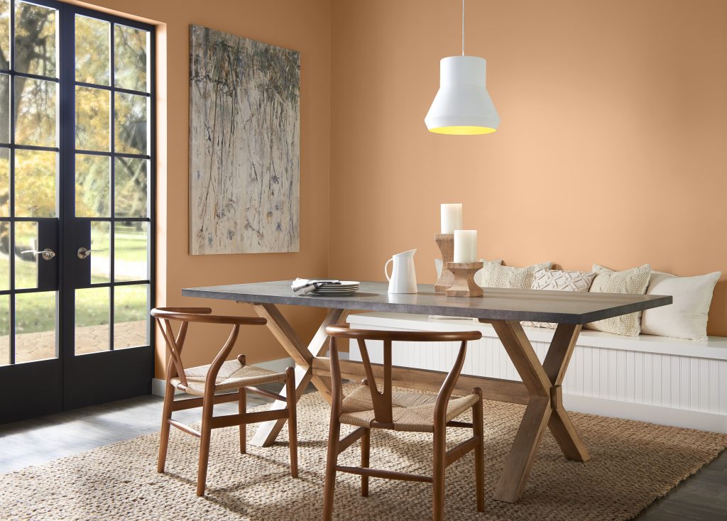A dining area with the walls painted in an tanish-orange hue.