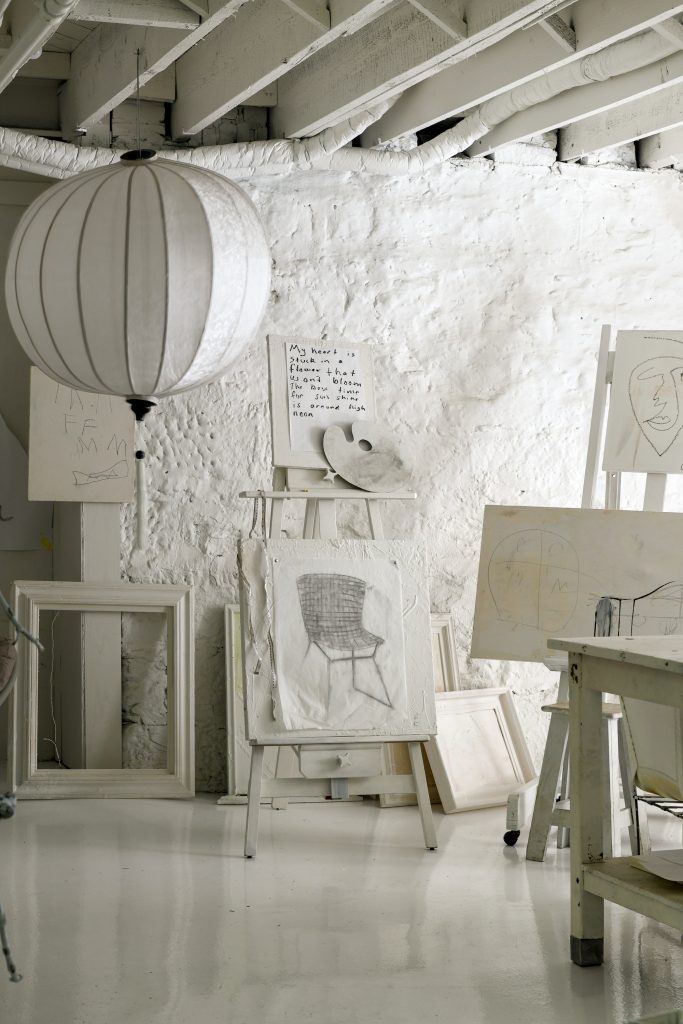 An area in the basement with a large lantern light, the space is used for painting.