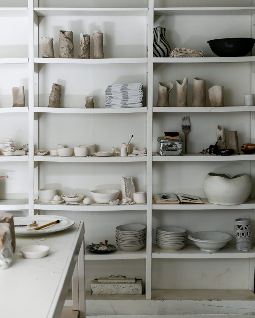 Shelving with pottery placed on them.