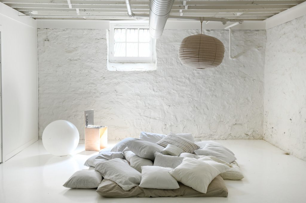 An area in the basement with a bunch of pillows piled up to use as a lounge area.
