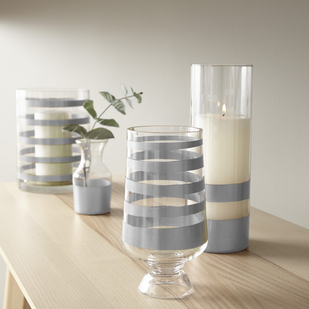 andles and vases on a table with metallic silver stripes.