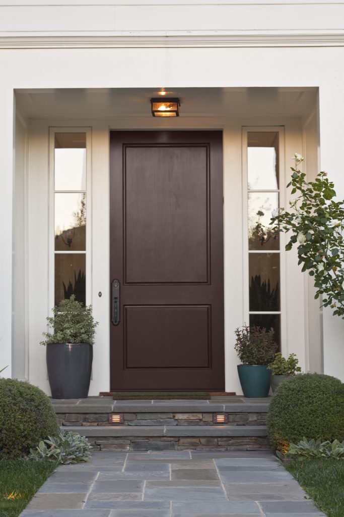 An entryway with the door painted in a burgandy hue.